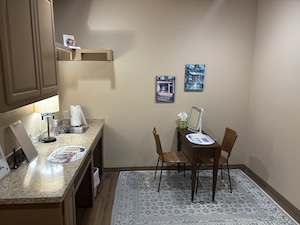 Photo of a contact lens fitting room with a table and chairs.